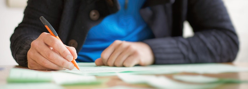 A person writing with a pen