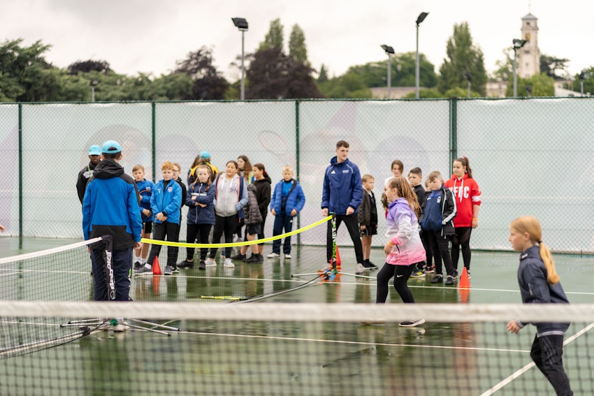 children playing sports with teachers on tennis courts