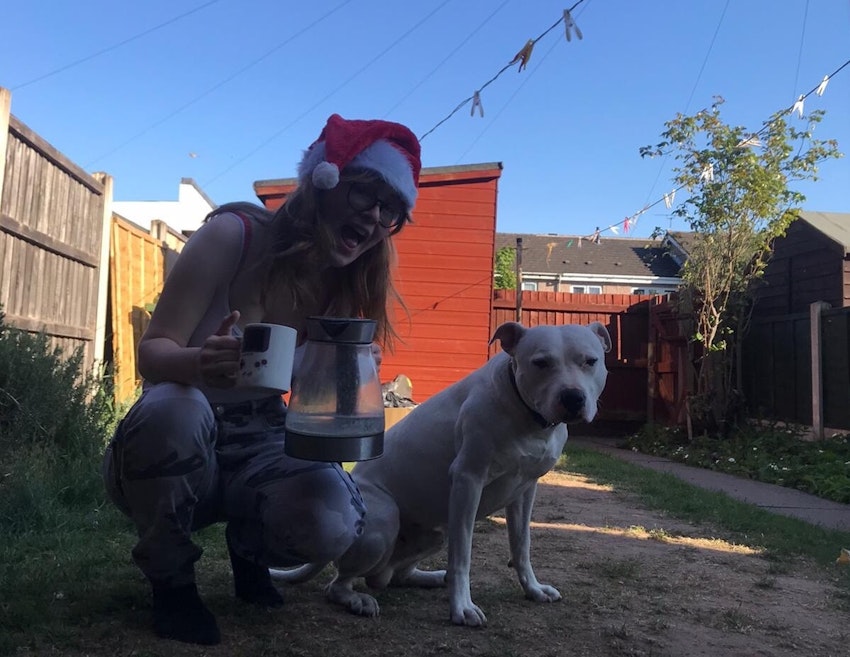 Student Emily with her pet dog Lez (and a cuppa) in her garden.