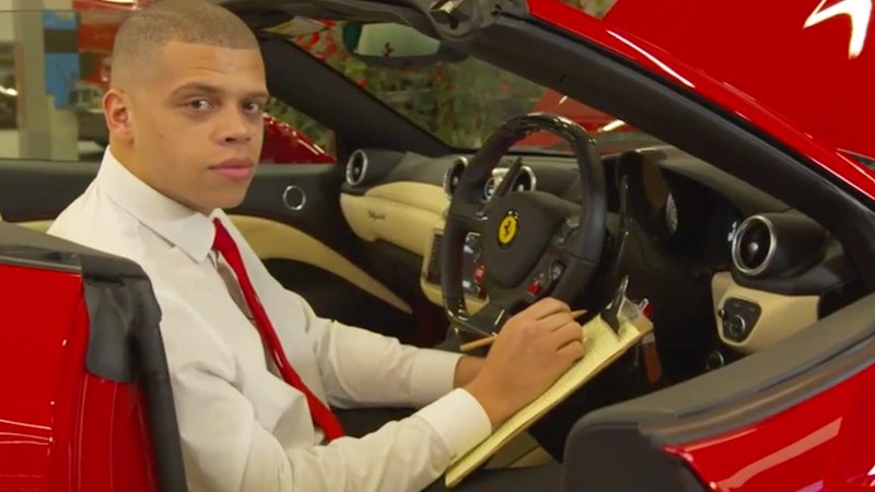 Ferrari apprentice sitting in the front of Ferrari with a clipboard